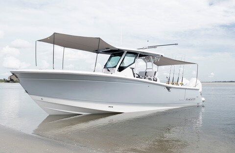 Large white speed boat with a canvas awning covering the deck