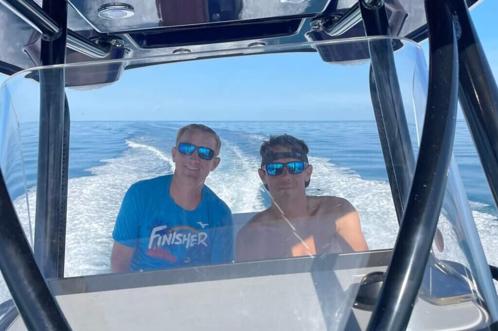 2 men driving a boat in the ocean of the coast of Hawaii