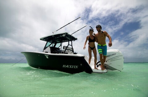 A man and woman snorkeling off the back of their Blackfin speed boat