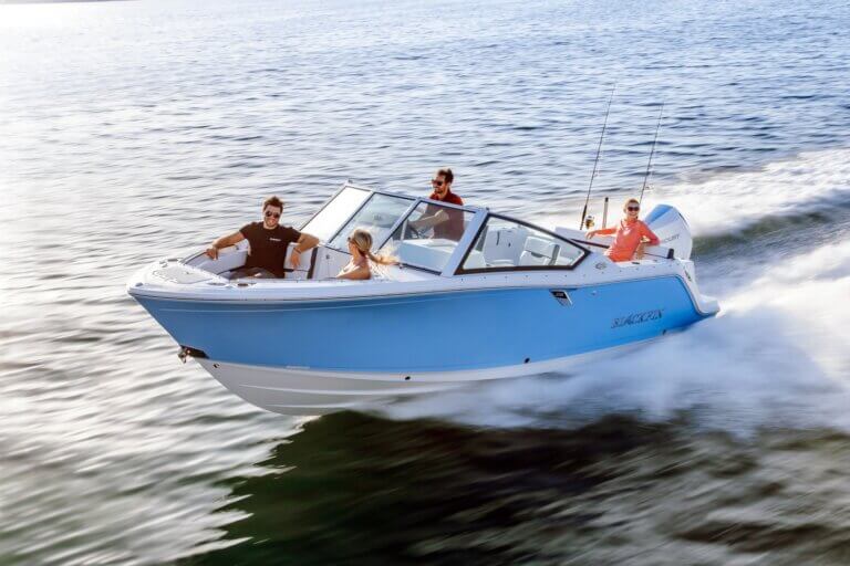 2 couples riding on a light blue Blackfin speed boat across open water