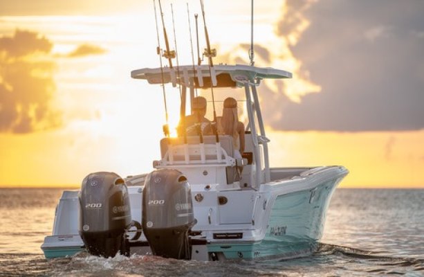 2 people riding a speed boat toward the sunset on the ocean in Hawaii